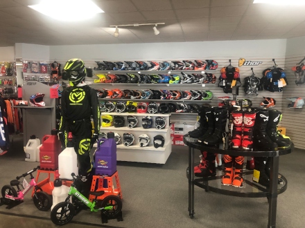 Helmets and powersport accessories placed on shelves and the floor.