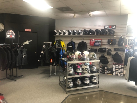 Back end of the parts department with helmets and riding jackets on display.